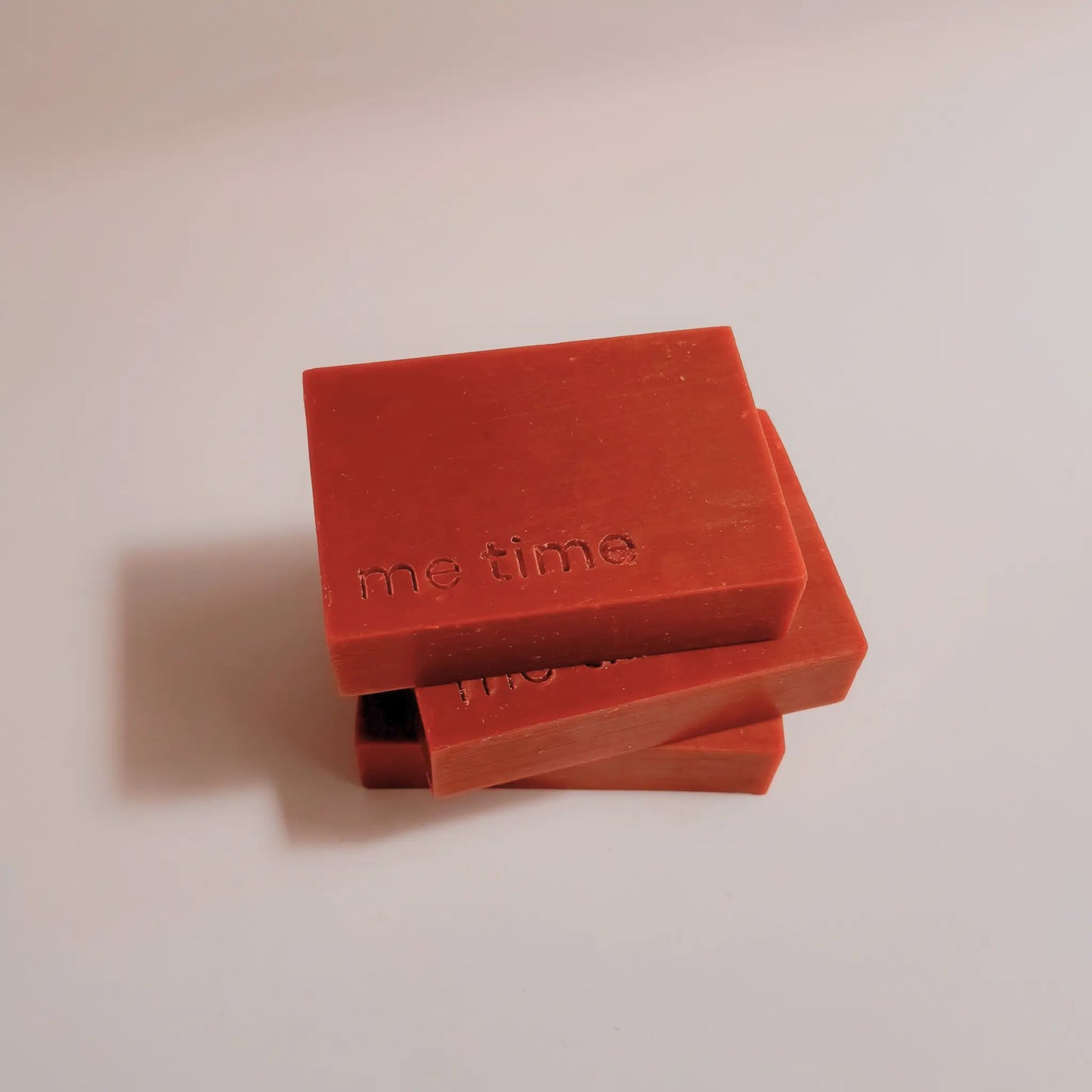 Two red soap bars with 'me time' text on a light beige background
